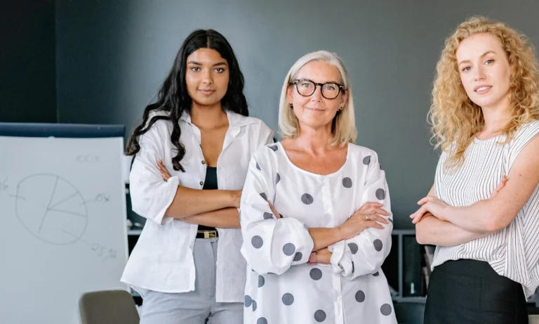 A group of women standing with their arms folded