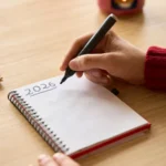 A person writing into a journal for 2026